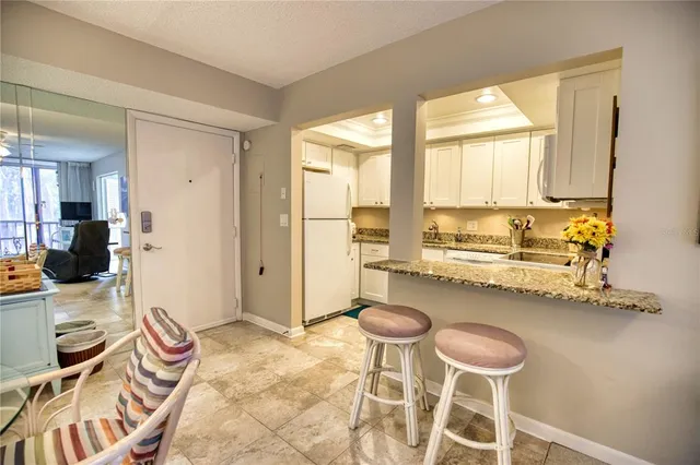 a kitchen with a sink and chairs