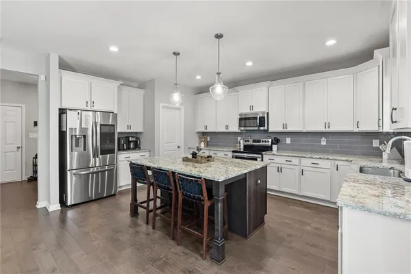 a kitchen that has a lot of cabinets in it and stainless steel appliances