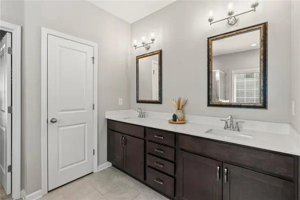 a bathroom with double vanity sinks and a mirror
