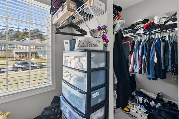 a view of walk in closet with clothes and shoes