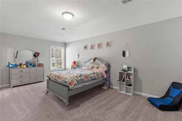 a bedroom with a bed and a dresser in it