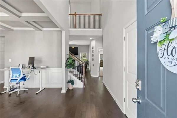a view of a hallway with workspace and wooden floor
