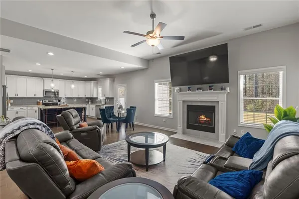 a living room with furniture a flat screen tv and a fireplace
