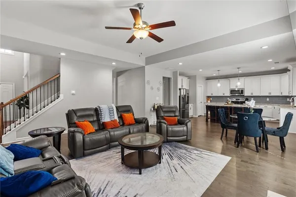 a living room with furniture kitchen view and a chandelier
