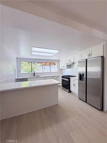 a kitchen with refrigerator and cabinets