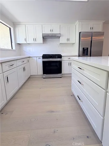 a kitchen with cabinets stainless steel appliances and sink