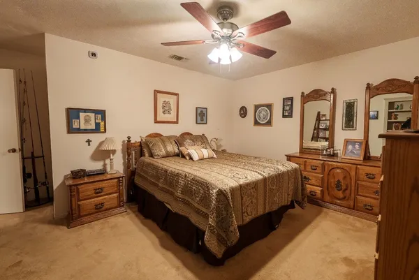 a spacious bedroom with a bed and a chandelier