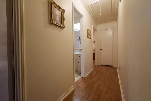 a view of a hallway with wooden floor