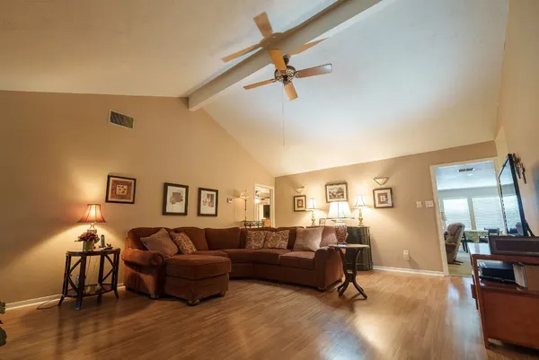 a living room with furniture and a wooden floor