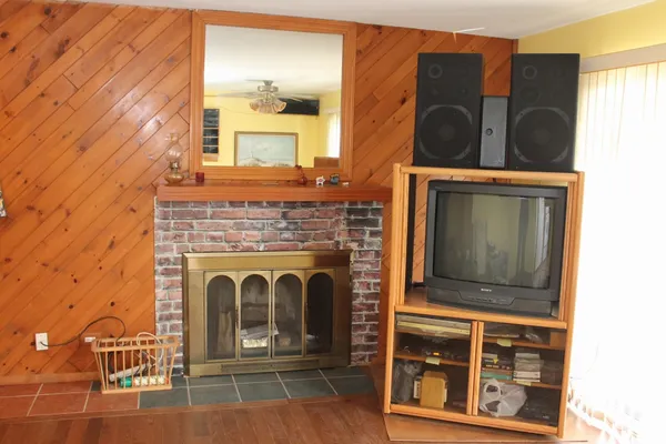 a living room with stainless steel appliances furniture a fireplace and a flat screen tv