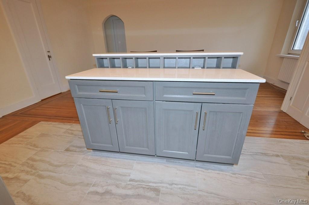 69 Harney Road, Unit 3A Scarsdale, NY 10583 - Photo 10 of 22 Renovated Kitchen with center Island, pendent lighting, Granite Counters, Stainless Steel Appliance including a dishwasher, range, microwave and refrigerator. The wall separating the eat-in-kitchen and living room have been removed and a center Island installed with electric and USB outlets installed to create an open concept.