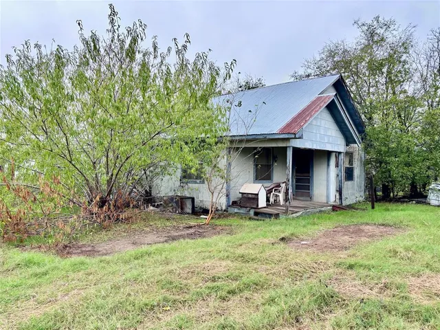 a view of a house with a yard and sitting area
