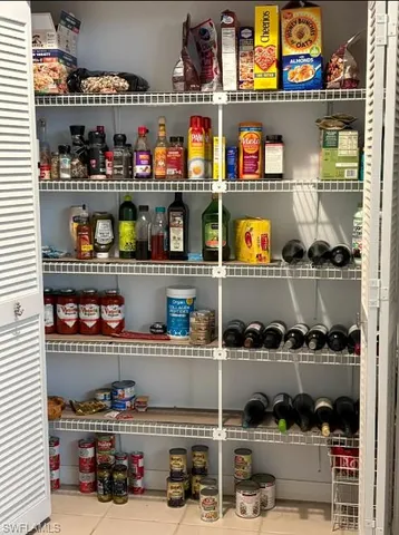 a store room with granite countertop lots of different kinds of food and vegetables