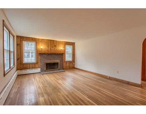 81 Sylvan Road Lancaster, MA 01523 - Photo 9 of 23 a view of an empty room with wooden floor fireplace and a window