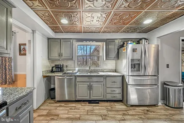 a kitchen with stainless steel appliances granite countertop a stove a refrigerator and a refrigerator