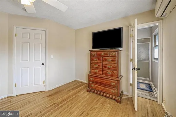 a view of room with wooden floor and flat screen tv