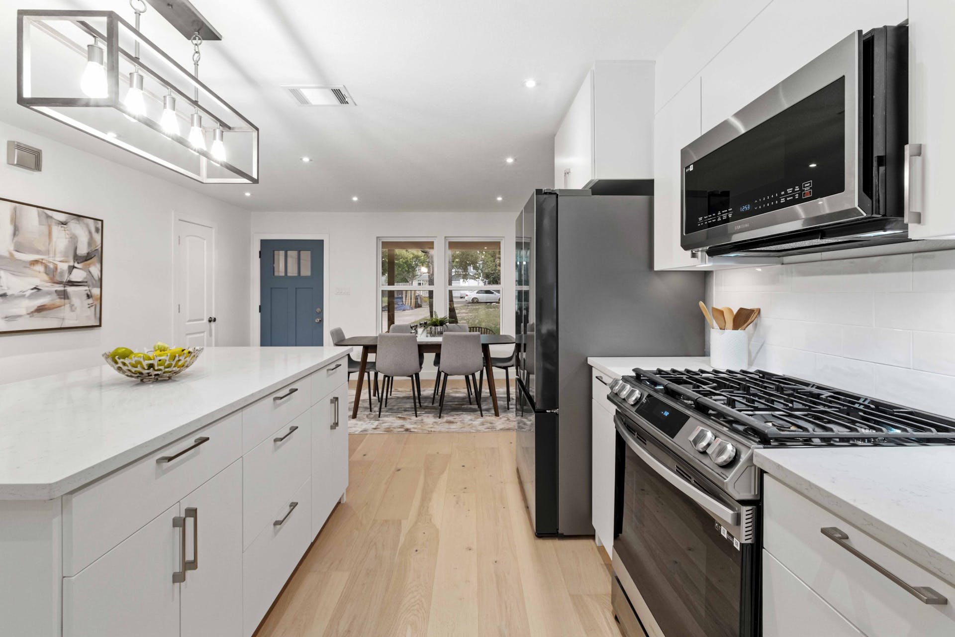 13207 Fencerail Road Manchaca, TX 78652 - Photo 16 of 36 Kitchen with stainless steel appliances, frameless plywood cabinets, and quartz countertops