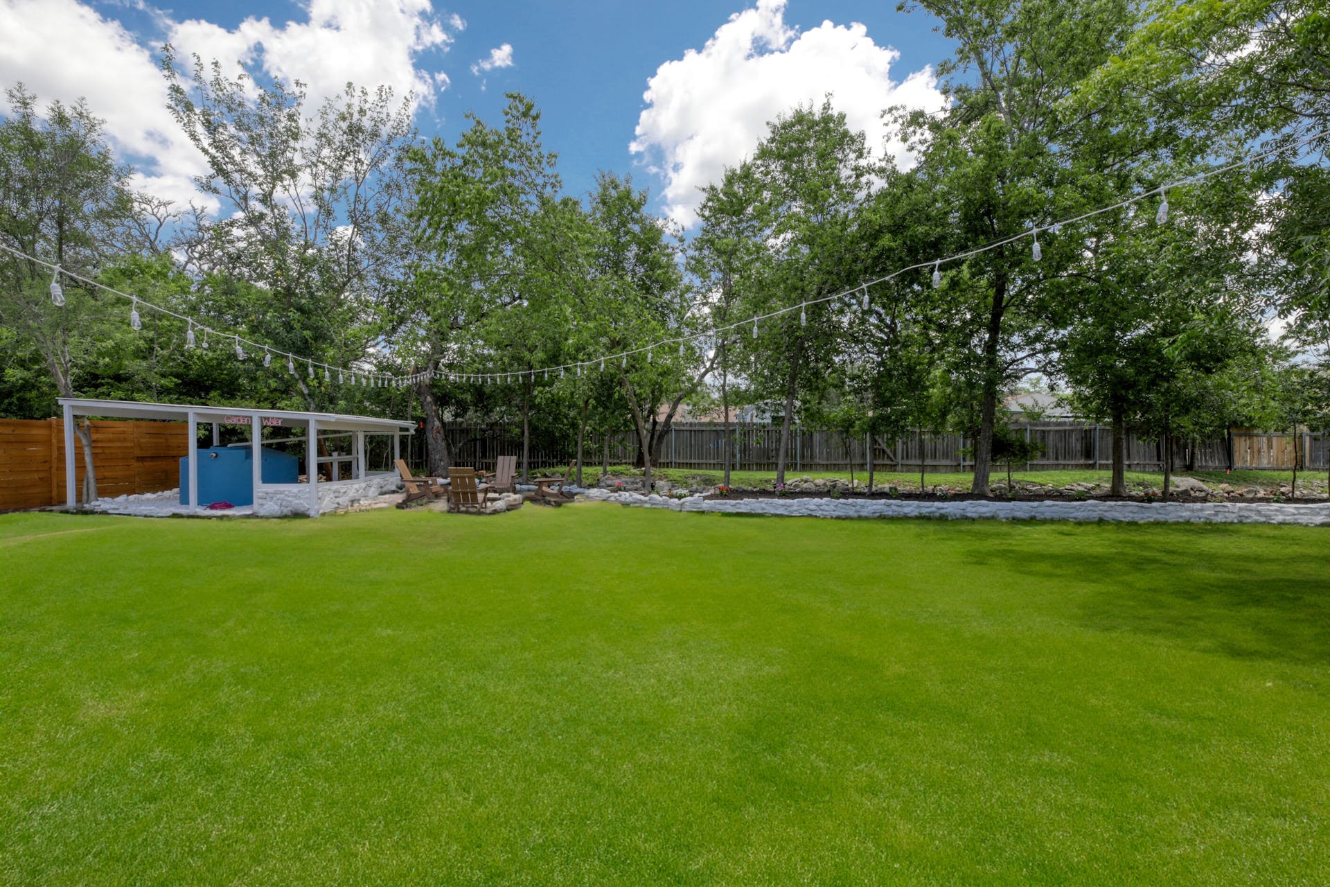 13207 Fencerail Road Manchaca, TX 78652 - Photo 25 of 36 Large backyard with bistro lights
