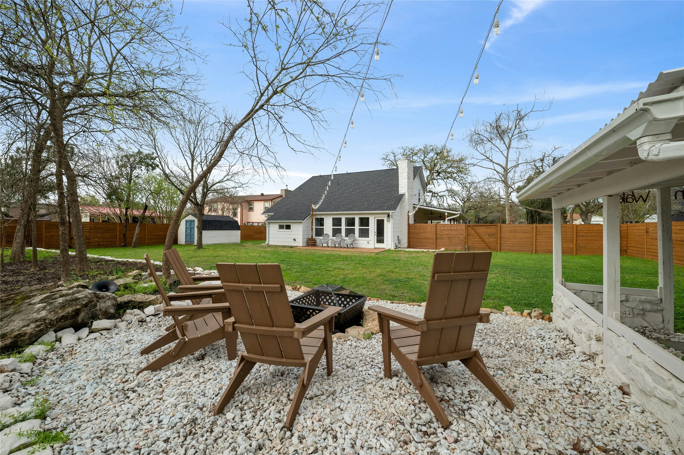 13207 Fencerail Road Manchaca, TX 78652 - Photo 27 of 36 Fenced backyard featuring an outdoor fire pit, a patio, and a storage shed