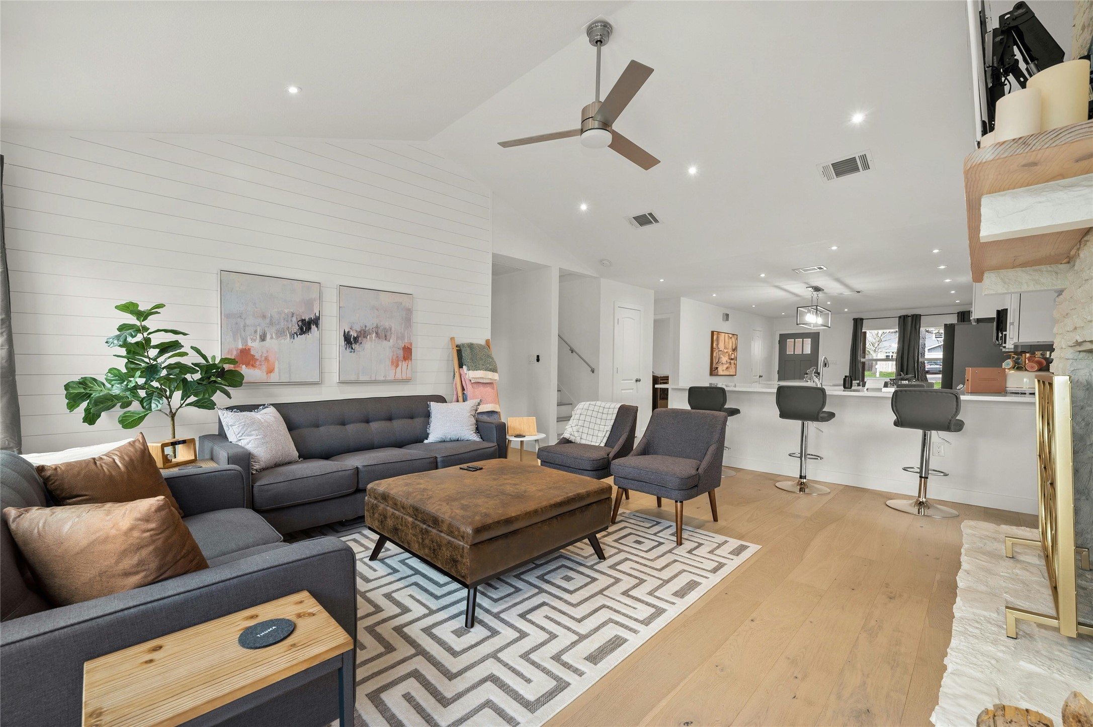 13207 Fencerail Road Manchaca, TX 78652 - Photo 3 of 36 Living area with light 7" white oak flooring, vaulted ceiling, and recessed lighting with custom accent wall