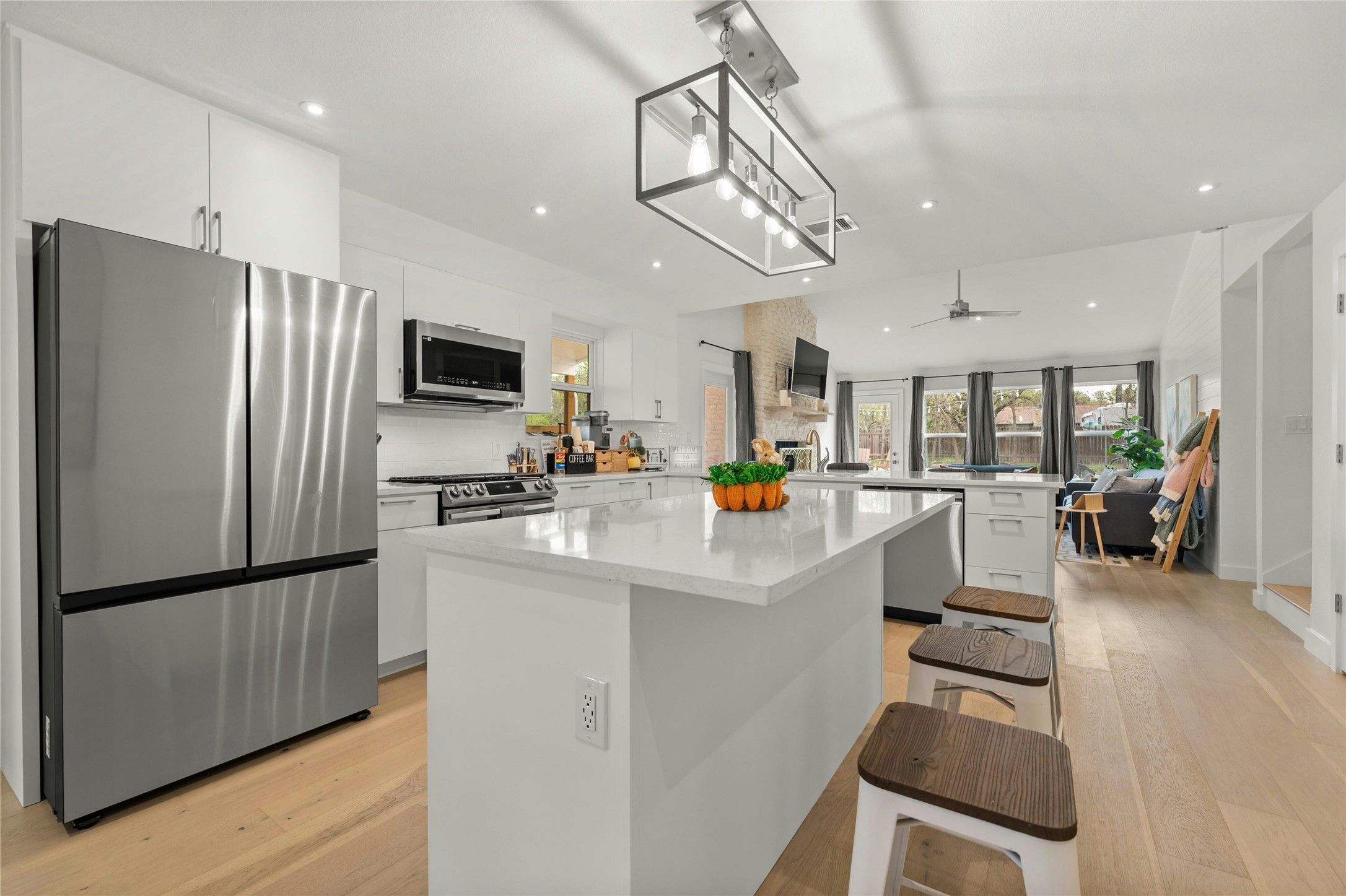 13207 Fencerail Road Manchaca, TX 78652 - Photo 4 of 36 Kitchen with stainless steel appliances, a peninsula, and a kitchen island perfect for entertaining guests!