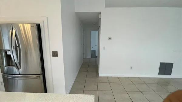 a view of kitchen with stainless steel appliances wooden floor and chair
