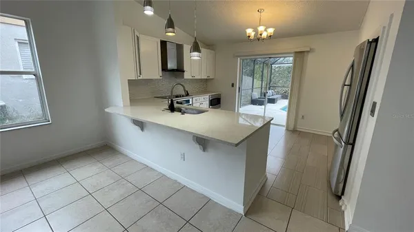 a view of a kitchen with stainless steel appliances a sink and a refrigerator