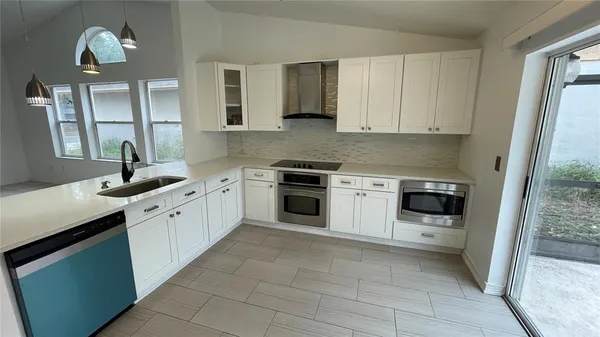 a kitchen with a stove sink and cabinets