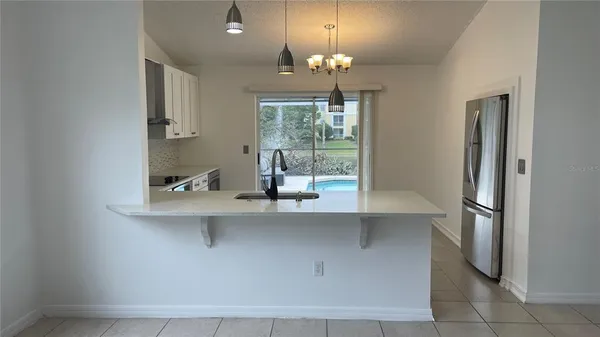 a view of a kitchen with a sink and chandelier