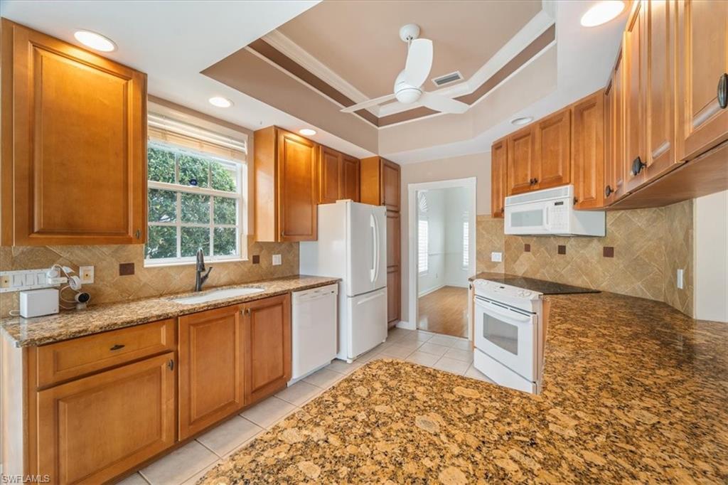 3956 Isla Ciudad Court Naples, FL 34109 - Photo 14 of 31 a kitchen with a sink stove and refrigerator