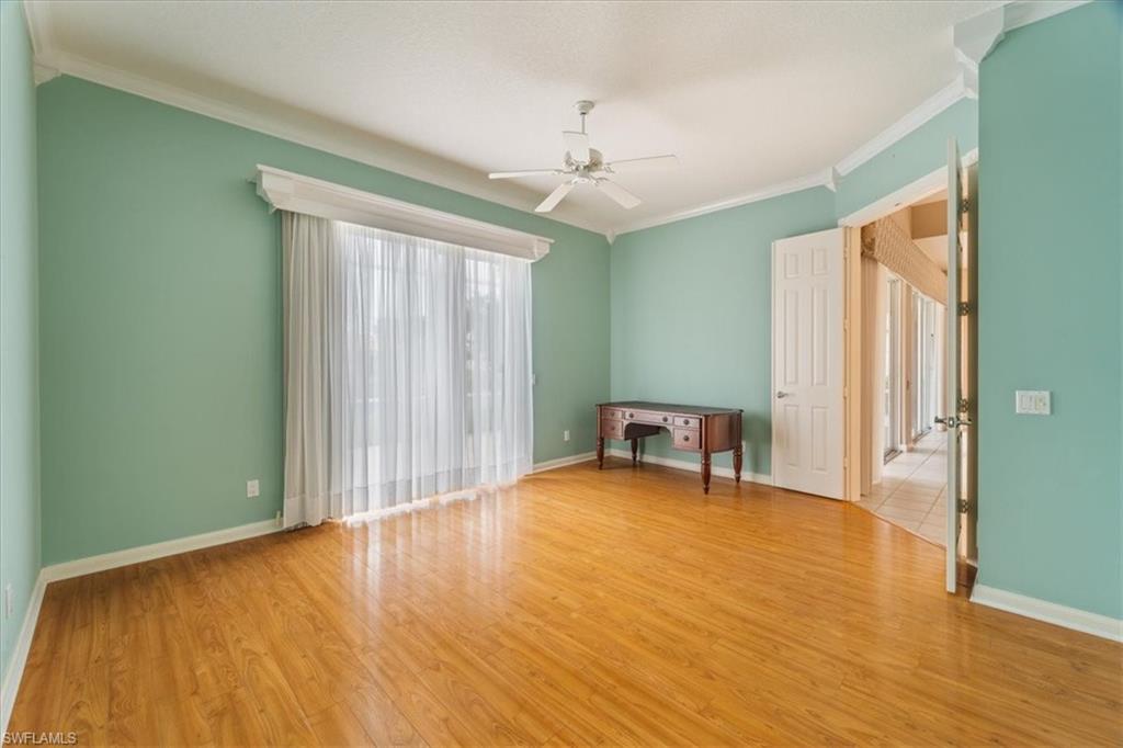 3956 Isla Ciudad Court Naples, FL 34109 - Photo 16 of 31 an empty room with wooden floor and windows
