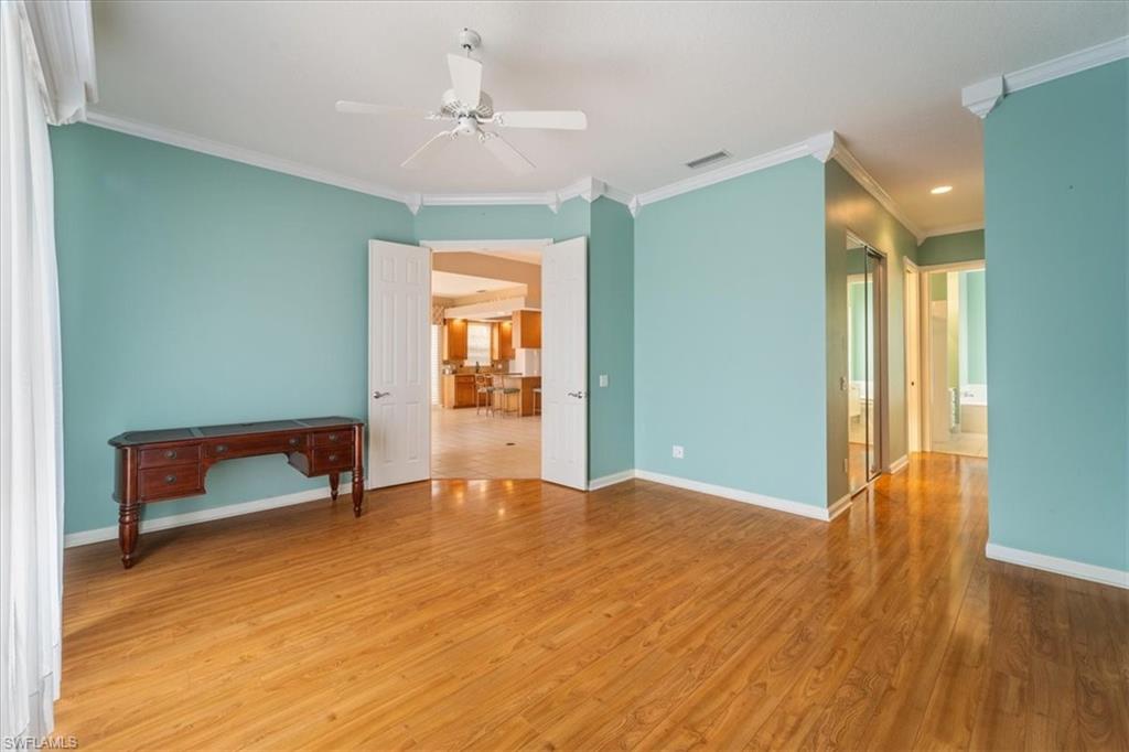 3956 Isla Ciudad Court Naples, FL 34109 - Photo 17 of 31 a view of an empty room with window and wooden floor