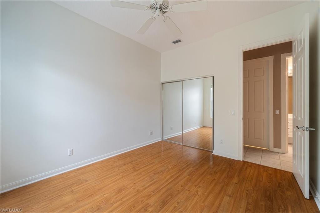 3956 Isla Ciudad Court Naples, FL 34109 - Photo 26 of 31 a view of an empty room with wooden floor and a ceiling fan