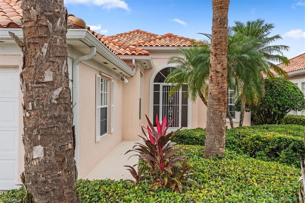 3956 Isla Ciudad Court Naples, FL 34109 - Photo 3 of 31 front view of a house with a flower garden