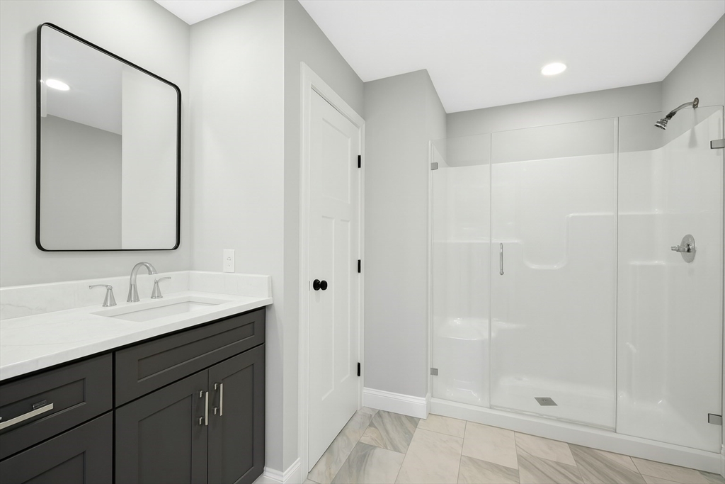 2 A Wilson Road, Unit A Millbury, MA 01527 - Photo 14 of 26 a bathroom with a shower sink and mirror