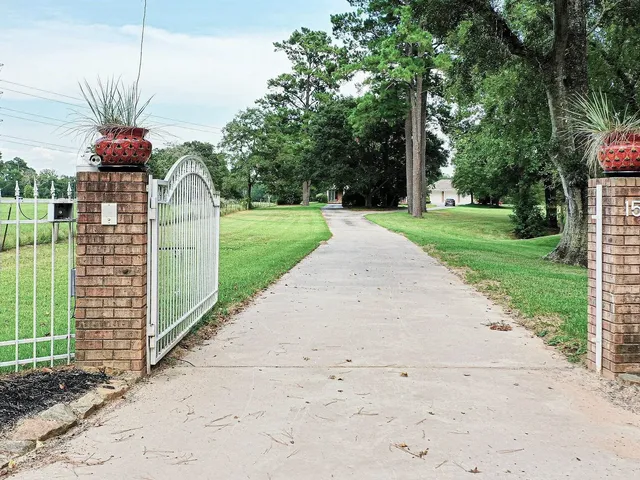 a front view of a house with a yard and potted plants