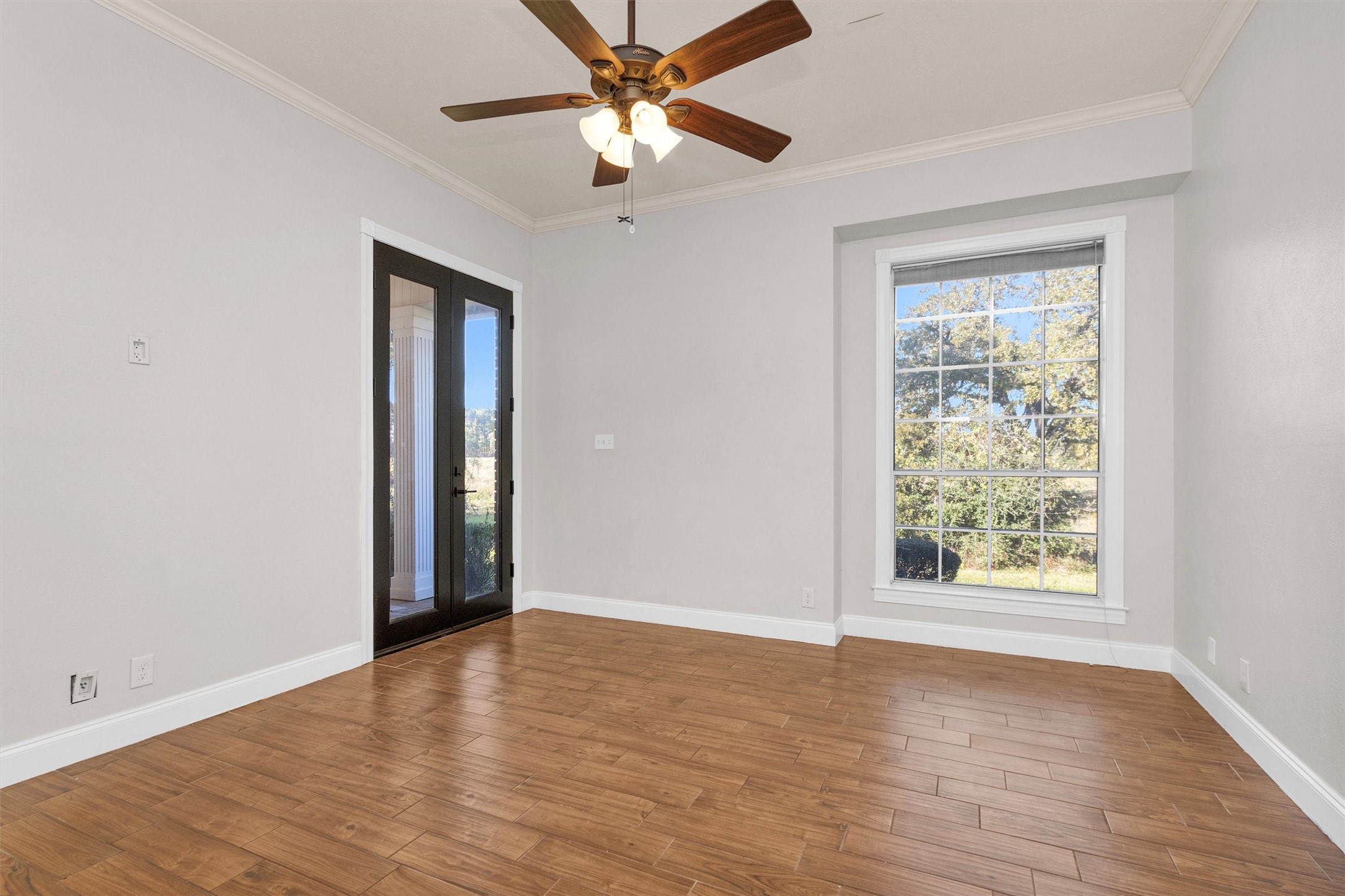 1548 Virgie Community Road Magnolia, TX 77354 - Photo 26 of 50 an empty room with wooden floor chandelier fan and windows
