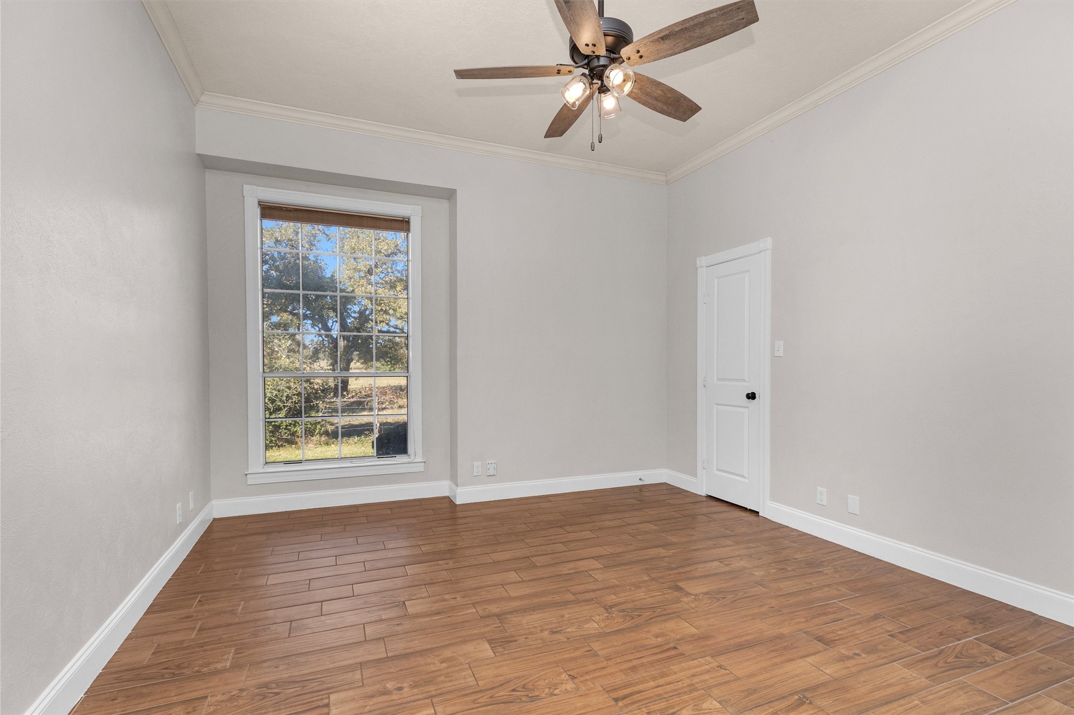 1548 Virgie Community Road Magnolia, TX 77354 - Photo 30 of 50 an empty room with wooden floor fan and windows