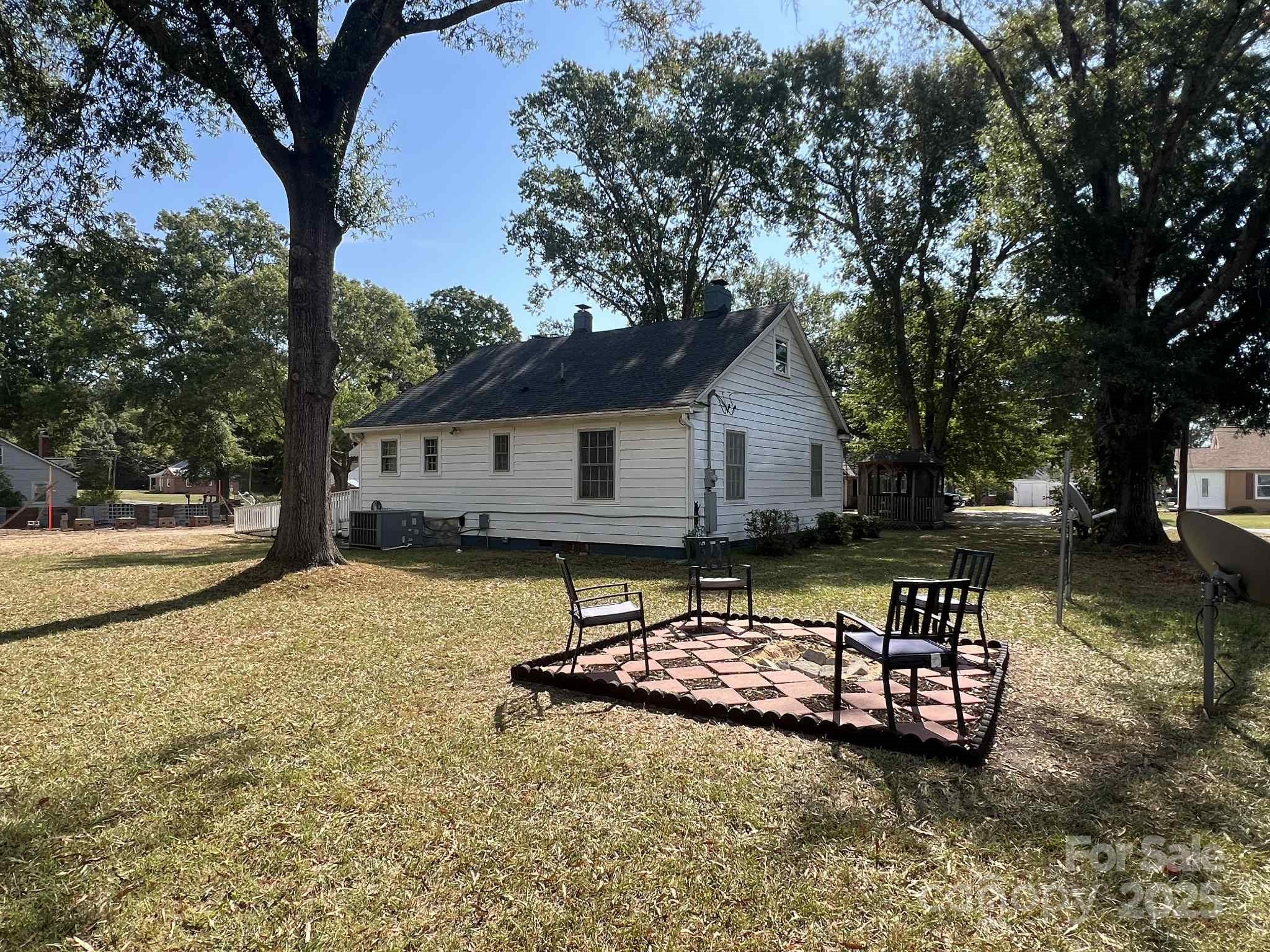 651 Still Street Chester, SC 29706 - Photo 7 of 27 a backyard of a house with table and chairs under an umbrella