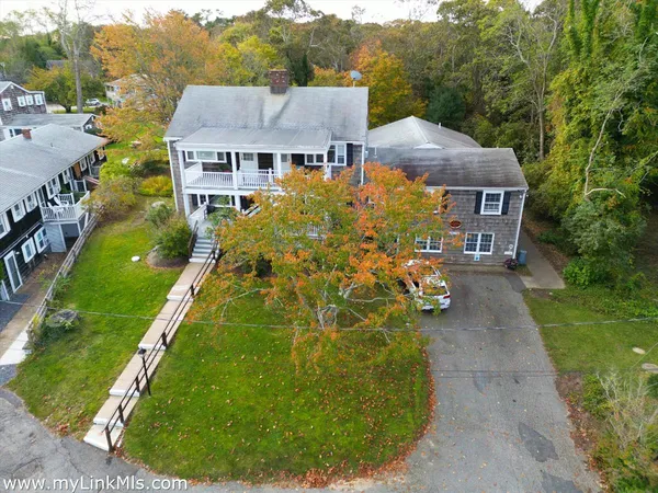 a view of a big house with a big yard and potted plants