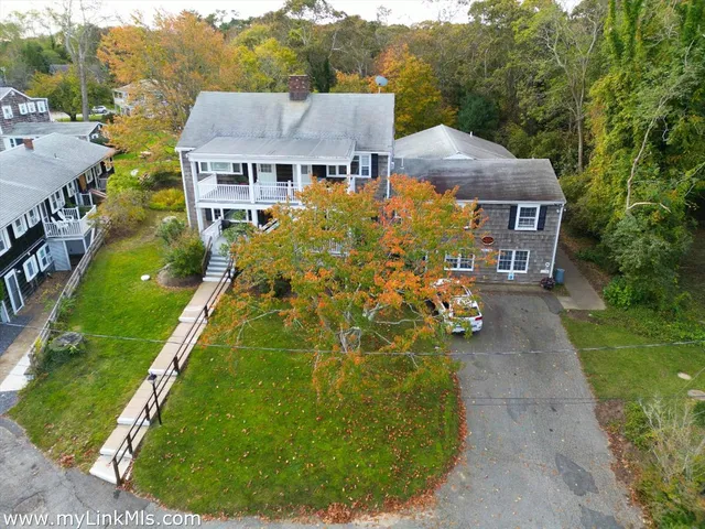 a view of a big house with a big yard and potted plants