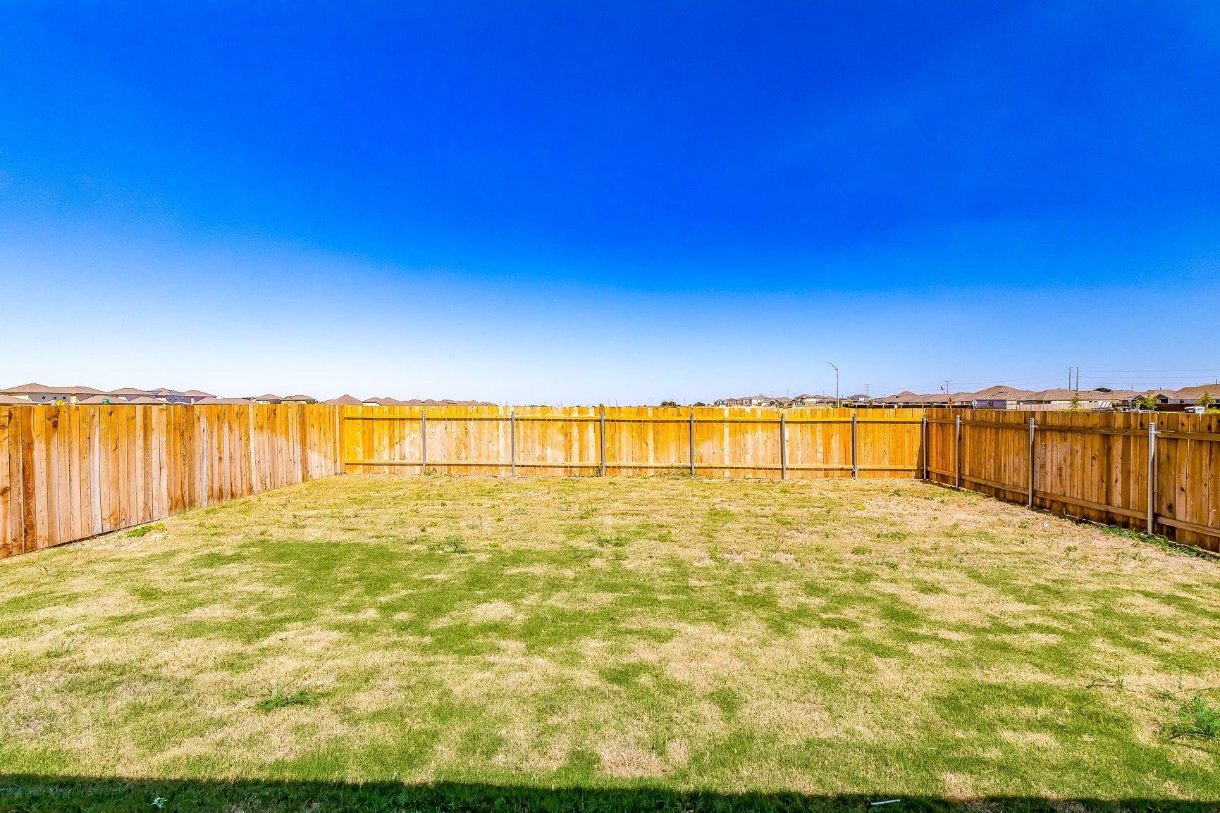 614 Milliner Loop Hutto, TX 78634 - Photo 5 of 25 A spacious backyard with privacy fencing awaits your personal touch.