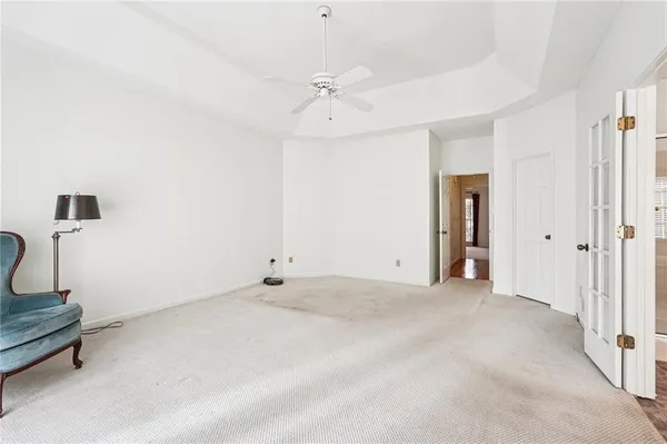 an empty room with windows and fan