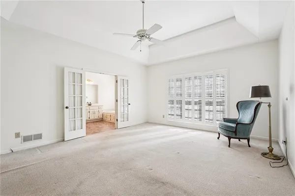 an empty room with windows and fan