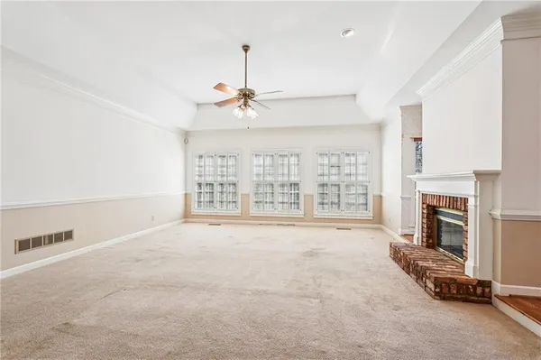 a view of a livingroom with a fireplace wooden floor and windows