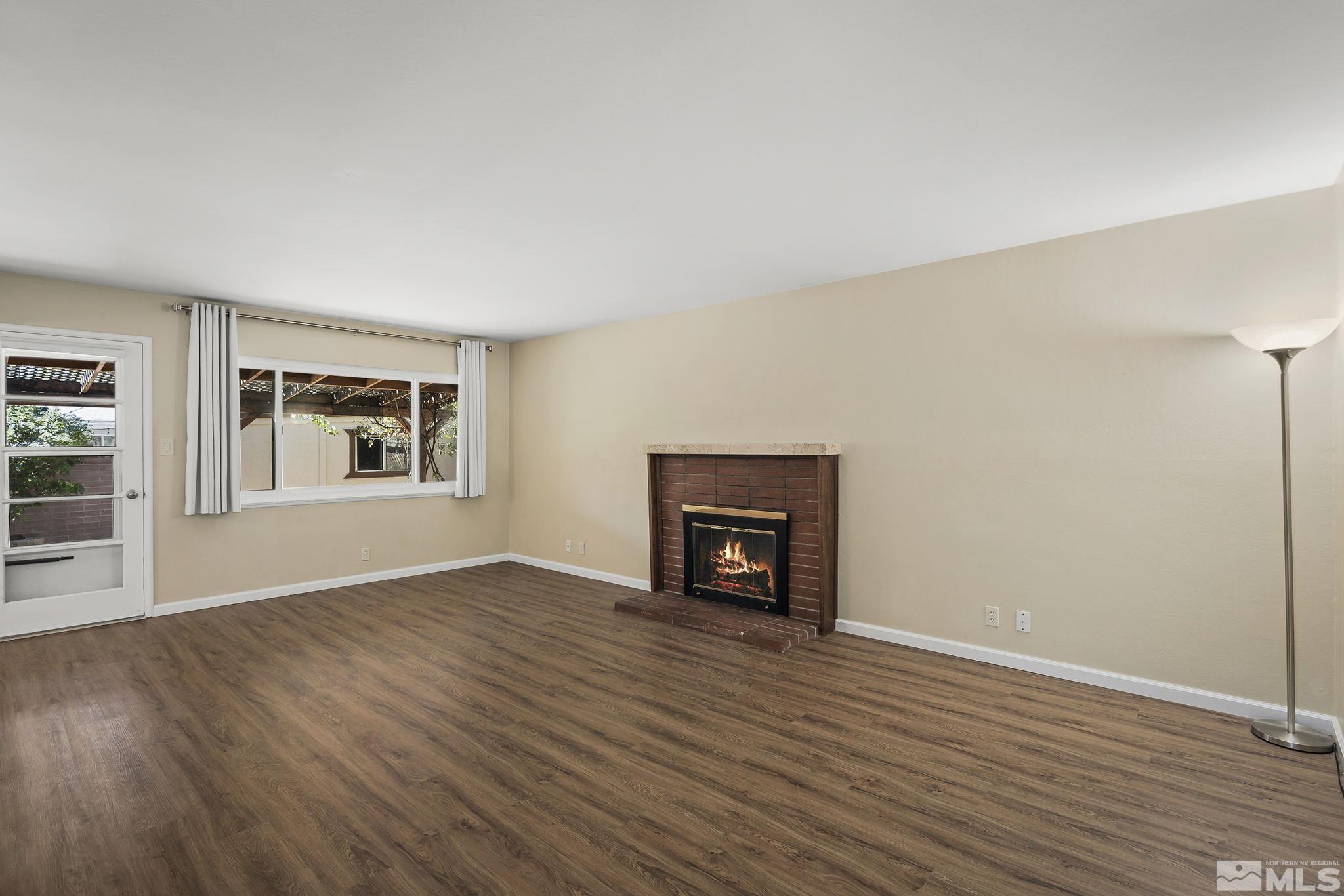 2050 Brisbane Avenue Reno, NV 89503 - Photo 8 of 24 an empty room with wooden floor fireplace and windows