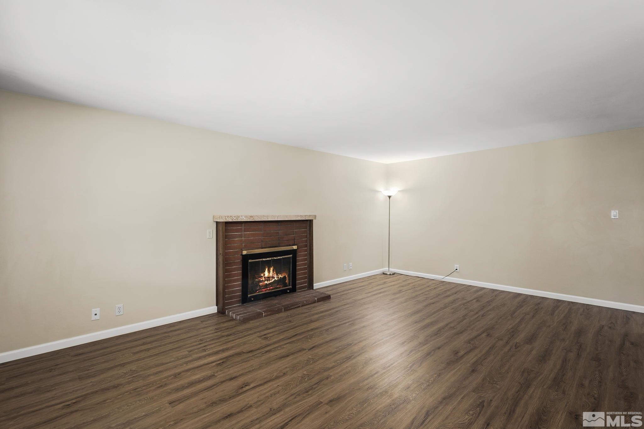 2050 Brisbane Avenue Reno, NV 89503 - Photo 9 of 24 a view of an empty room with wooden floor fireplace and a window