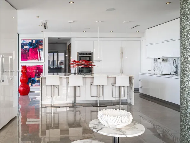 a kitchen with stainless steel appliances kitchen island granite countertop a table and chairs