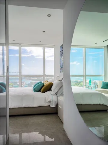 a bedroom with a bed and large window