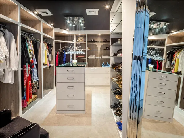 a view of walk in closet with clothes and shoes